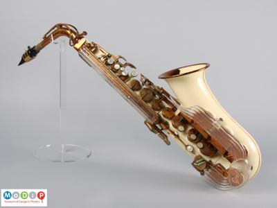 Side view of a saxophone showing the cream coloured and clear acrylic parts.