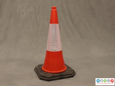 Front view of a traffic cone showing the black base and orange top section.