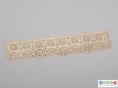Top view of a parkesine lace edging sample showing the lace like pattern and the thread like texture.